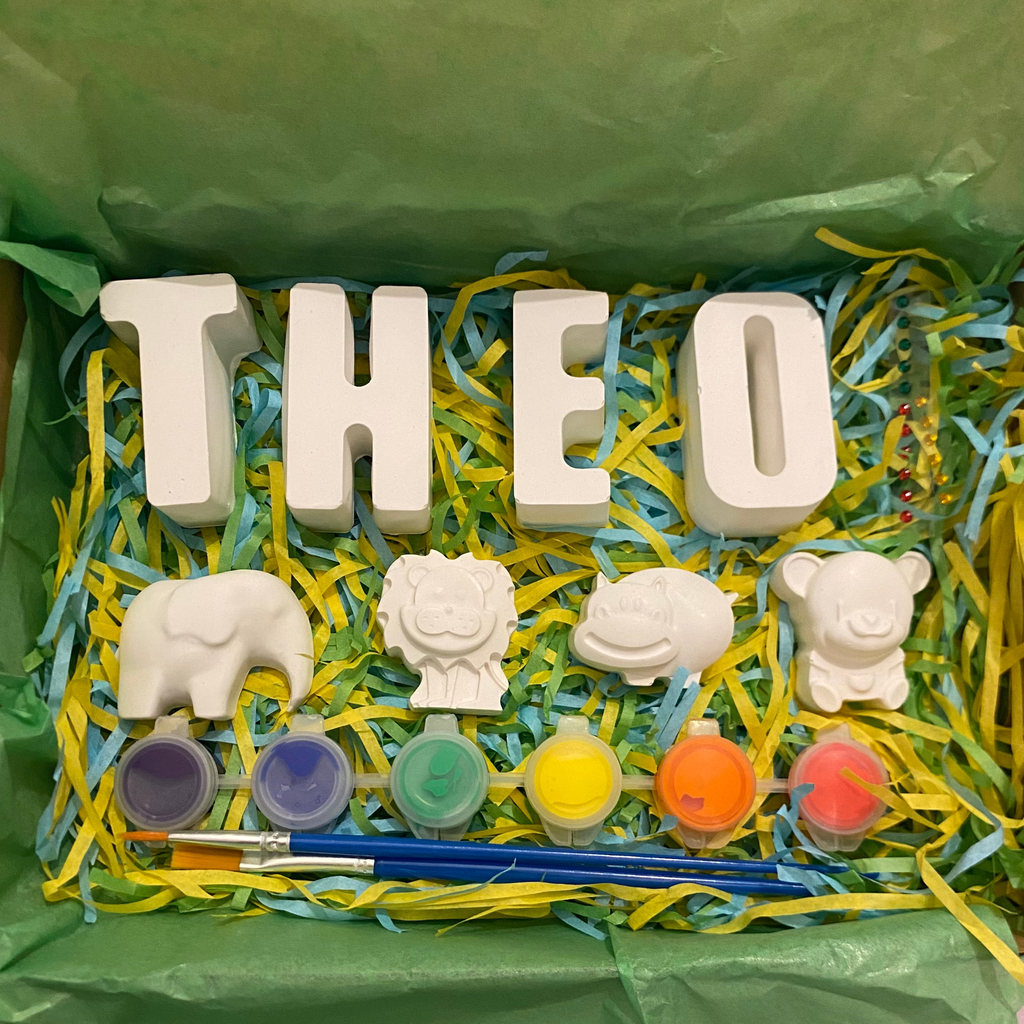 Animal paint kit with lion, elephant and bear moulds, paints and brush displayed flat lay
