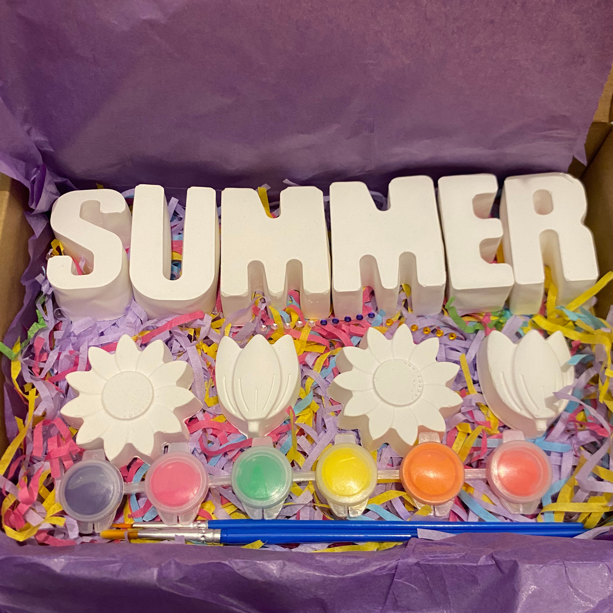 Flower paint kit with flower moulds, paints and brush displayed flat lay