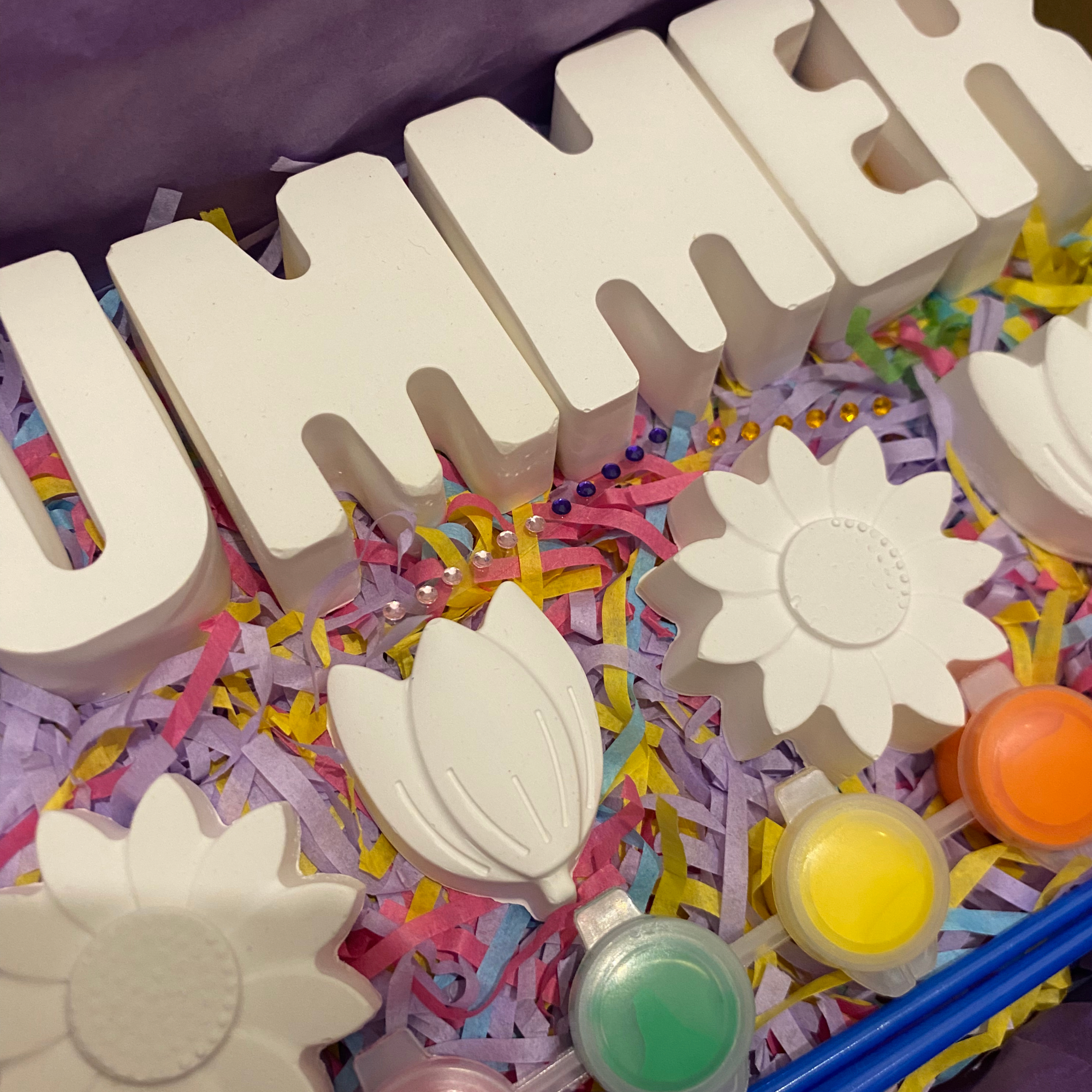 Flower theme DIY paint kit set up with paints, brushes and moulds ready to decorate